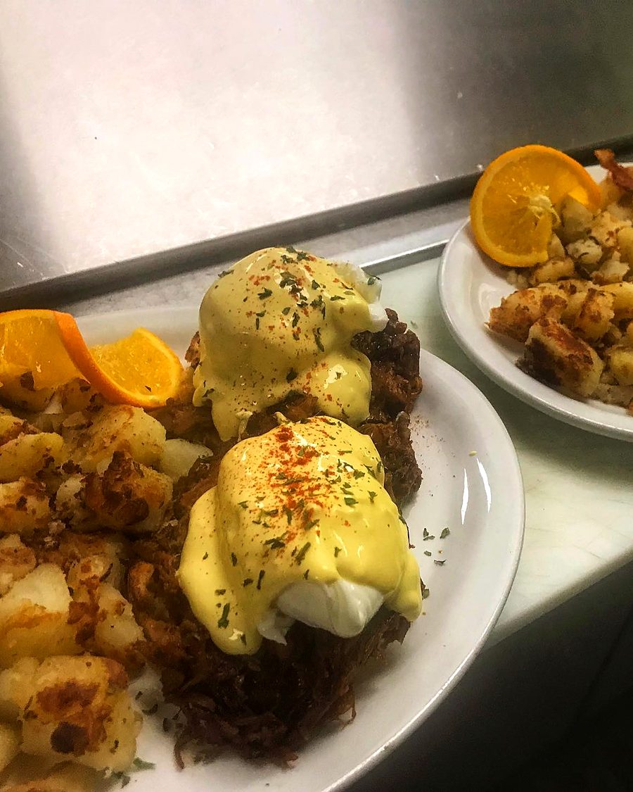 BBQ Pulled Pork Benny: poached eggs in hollandaise over slow-cooked pulled pork, with your choice of shredded or cubed hash browns and an orange slice