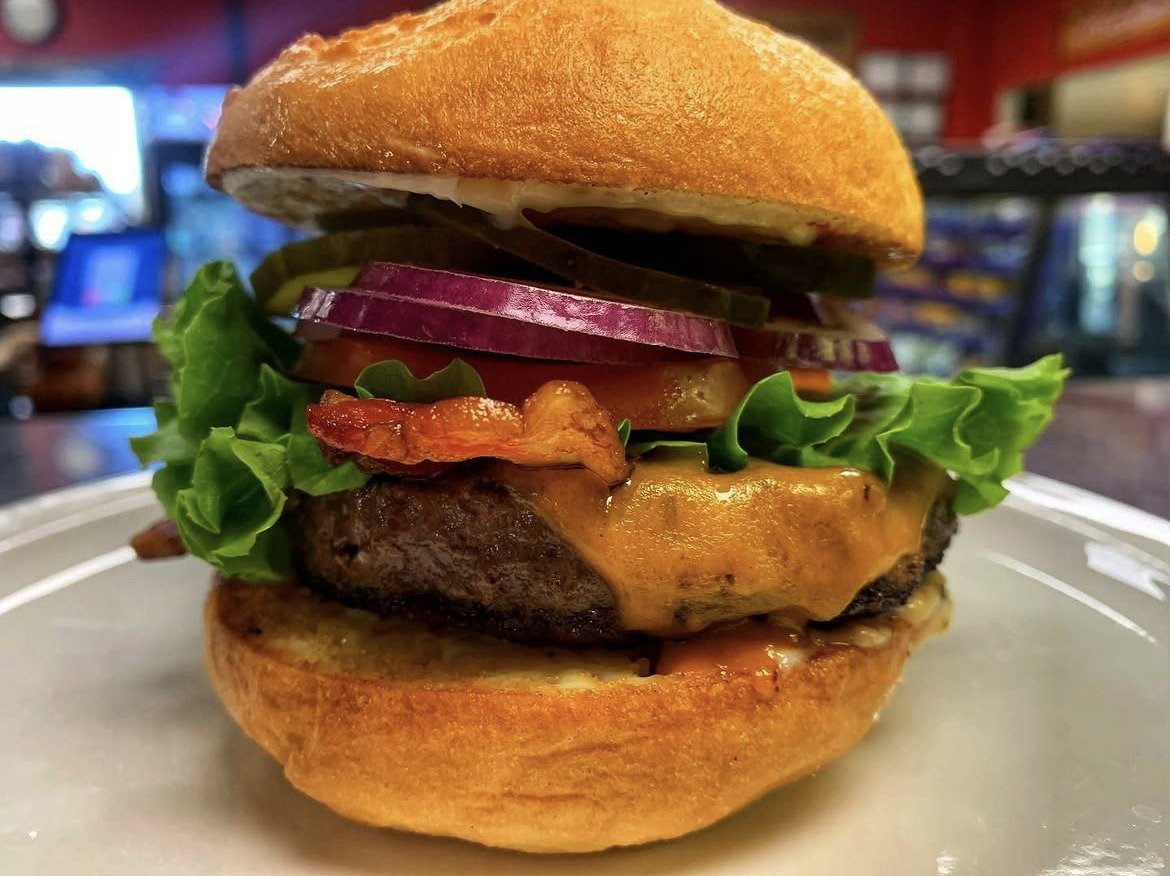 Wolf Burger: a cheeseburger with melted cheddar, bacon, lettuce, tomato, red onion and pickles on a toasted bun